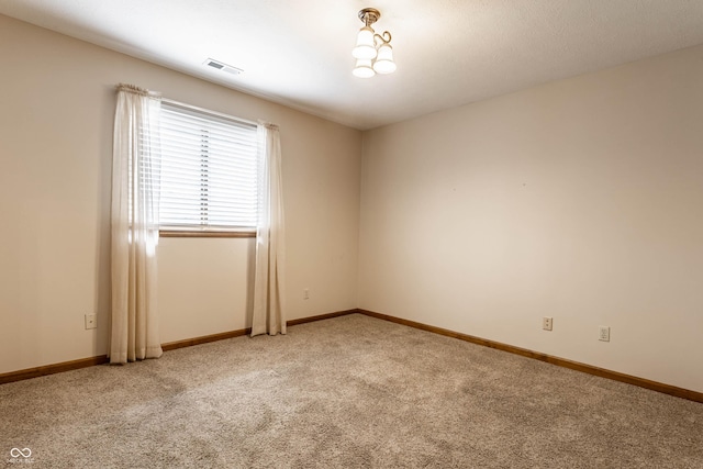 spare room with visible vents, light carpet, and baseboards