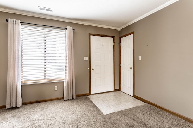 foyer entrance featuring baseboards, visible vents, ornamental molding, and light colored carpet