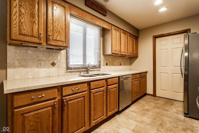 kitchen featuring recessed lighting, stainless steel appliances, a sink, brown cabinets, and tasteful backsplash