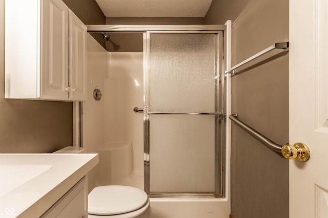 bathroom featuring toilet, an enclosed shower, a textured ceiling, and vanity