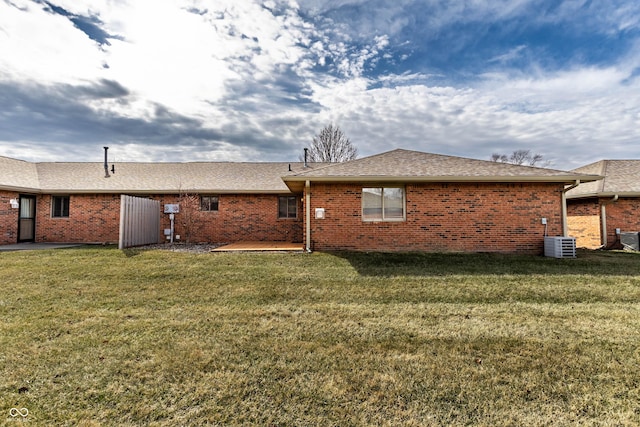 back of house with brick siding, a lawn, and a patio