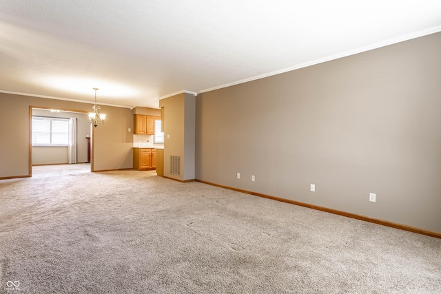 unfurnished living room featuring light colored carpet, visible vents, baseboards, ornamental molding, and an inviting chandelier