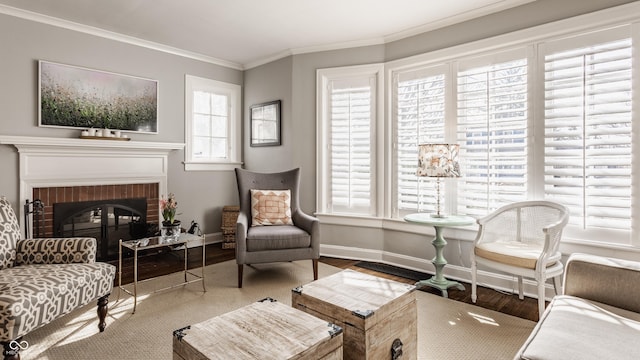 living area featuring a fireplace, baseboards, crown molding, and wood finished floors