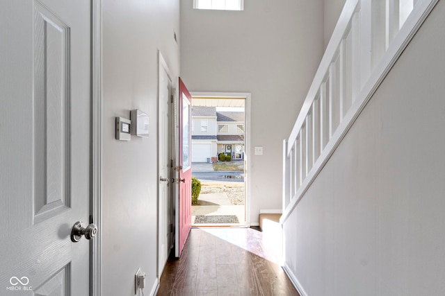 entrance foyer with dark wood-style floors and stairway