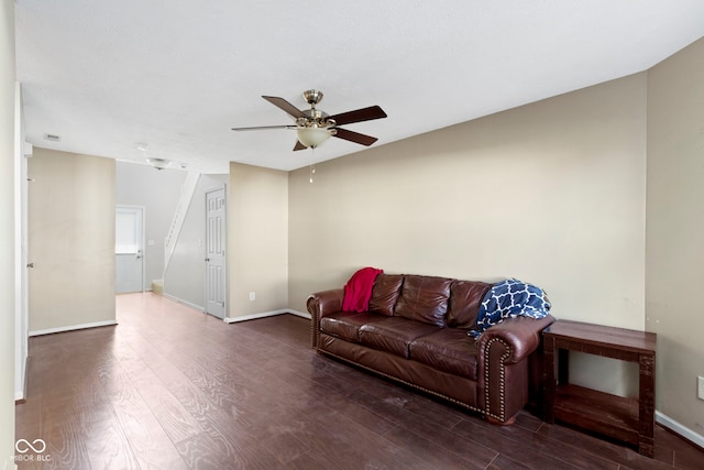 living area with a ceiling fan, baseboards, and wood finished floors