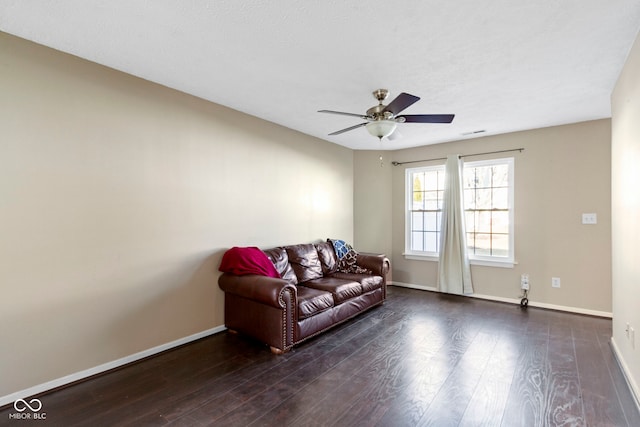 living area featuring a ceiling fan, visible vents, baseboards, and wood finished floors