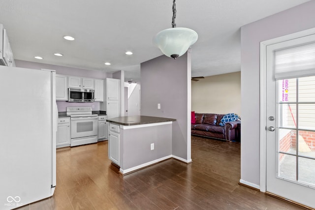 kitchen featuring dark countertops, dark wood-type flooring, white cabinetry, white appliances, and a peninsula