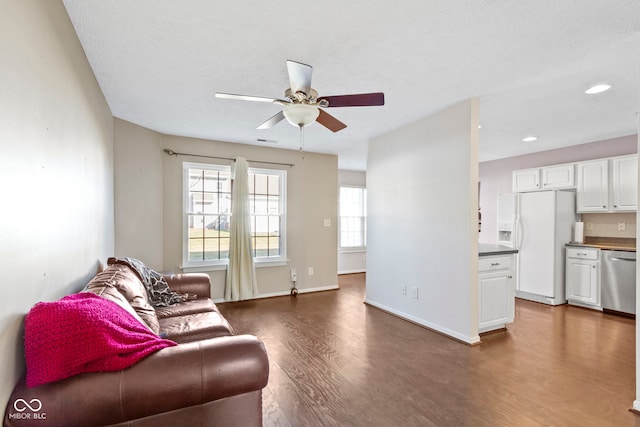 living area featuring recessed lighting, visible vents, a ceiling fan, wood finished floors, and baseboards