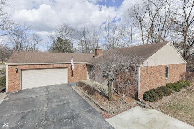 ranch-style home featuring brick siding, a chimney, a shingled roof, a garage, and driveway