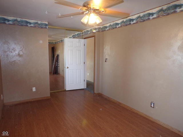 spare room with a ceiling fan, wood finished floors, and baseboards