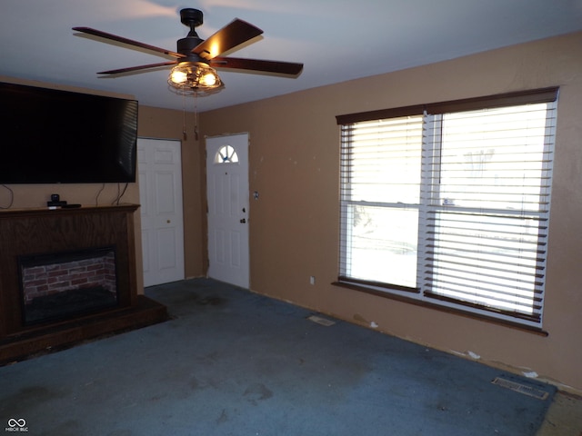 unfurnished living room with visible vents, a healthy amount of sunlight, and a fireplace with raised hearth