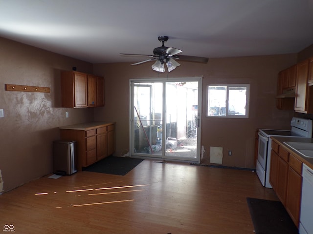 kitchen with light wood-style flooring, white appliances, and brown cabinets