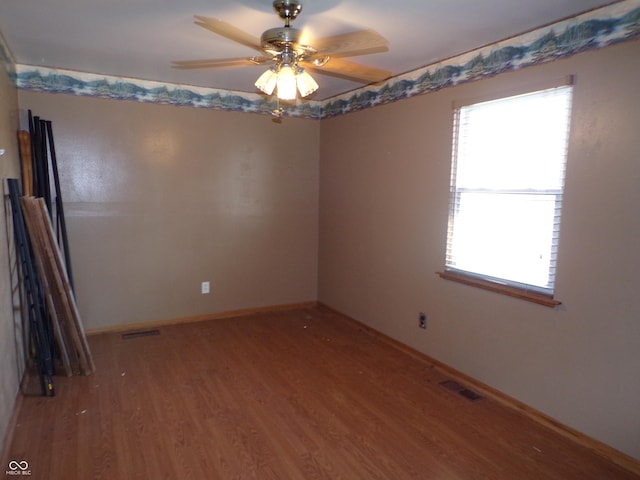 empty room with visible vents, plenty of natural light, and wood finished floors