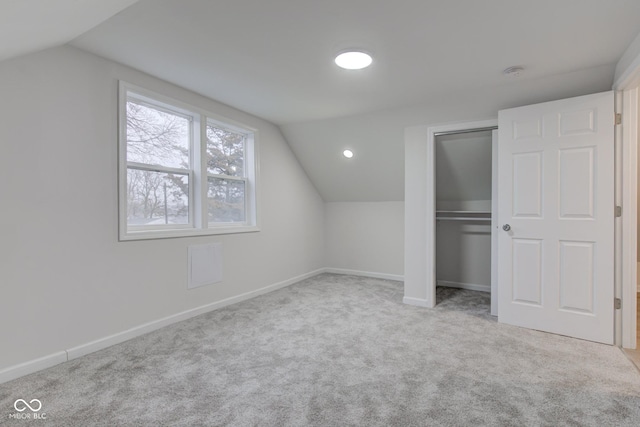 additional living space with lofted ceiling, baseboards, and carpet flooring