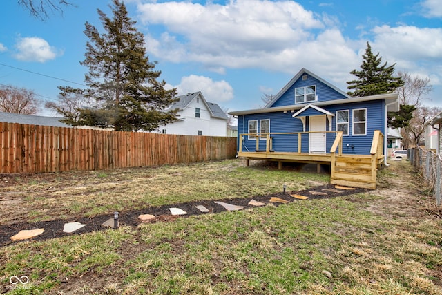 view of front of home featuring a front lawn, a fenced backyard, and a wooden deck