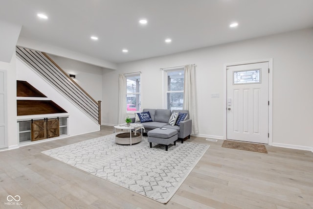 interior space featuring light wood-style floors, baseboards, stairway, and recessed lighting