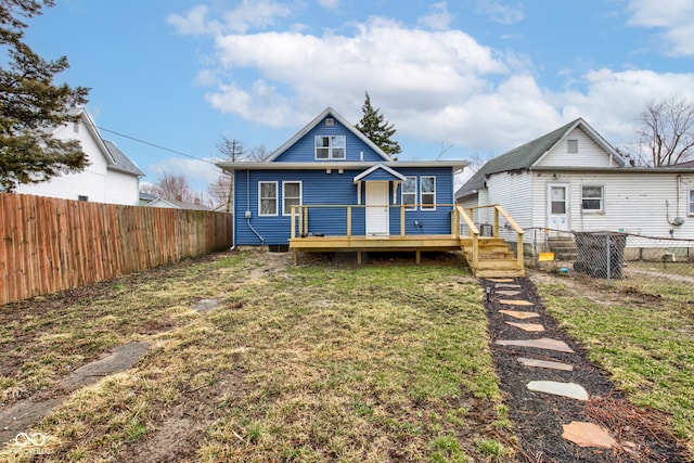 view of front facade featuring a deck, a front yard, and a fenced backyard