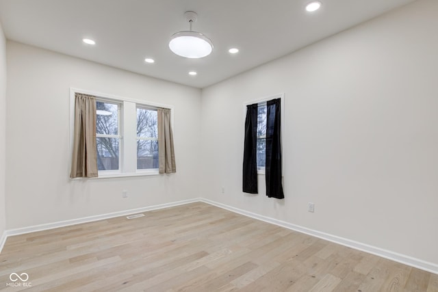 empty room featuring recessed lighting, visible vents, light wood-style flooring, and baseboards