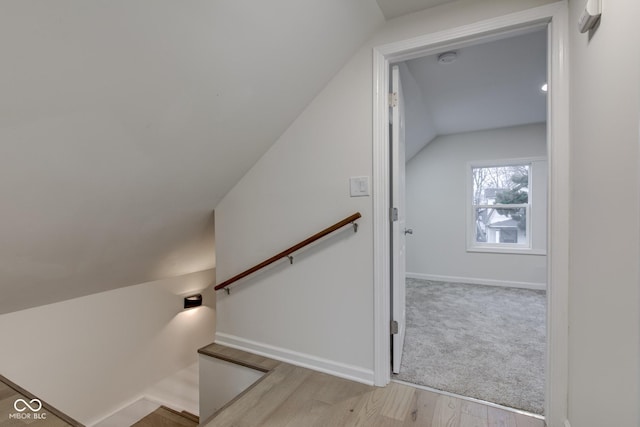 stairs with vaulted ceiling, wood finished floors, and baseboards