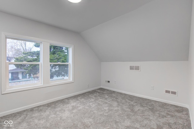 bonus room with carpet floors, visible vents, and vaulted ceiling