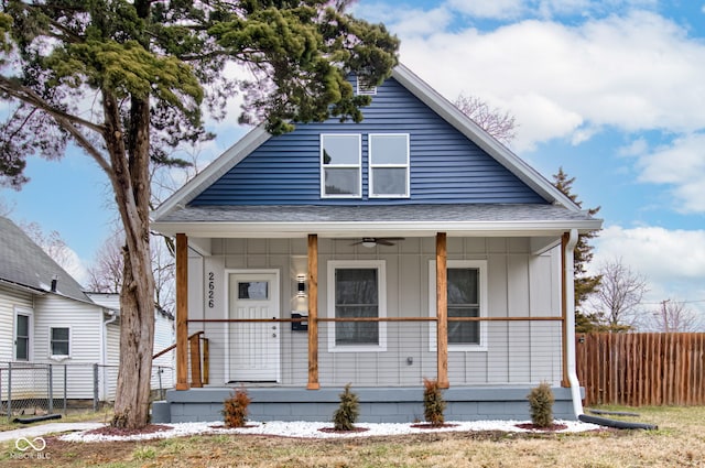 bungalow with ceiling fan, fence, covered porch, and a shingled roof