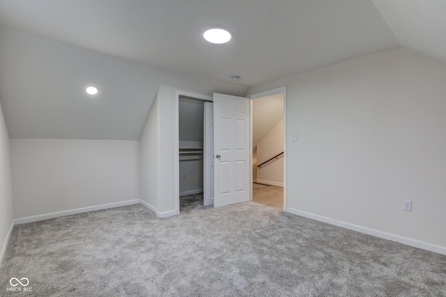 bonus room featuring lofted ceiling, carpet flooring, and baseboards