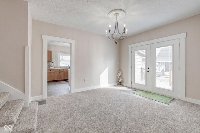 interior space featuring light carpet, baseboards, stairway, a textured ceiling, and a notable chandelier