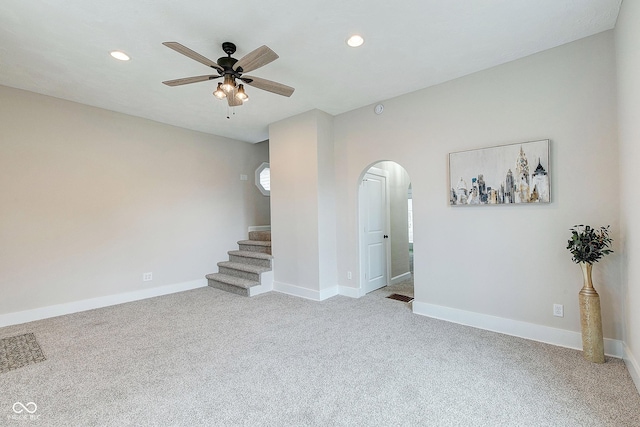 carpeted empty room featuring arched walkways, ceiling fan, recessed lighting, visible vents, and baseboards