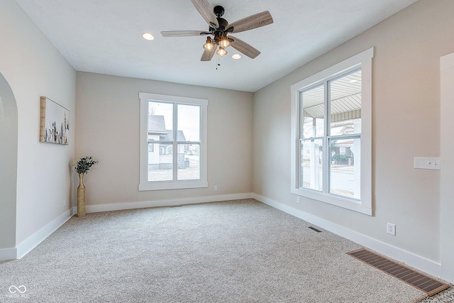 empty room featuring carpet, visible vents, and baseboards