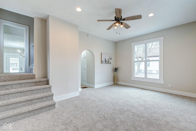 unfurnished room featuring carpet, baseboards, arched walkways, and recessed lighting