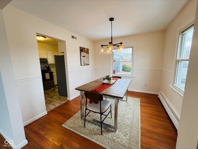 dining space featuring dark wood-style floors, a baseboard radiator, visible vents, and baseboards