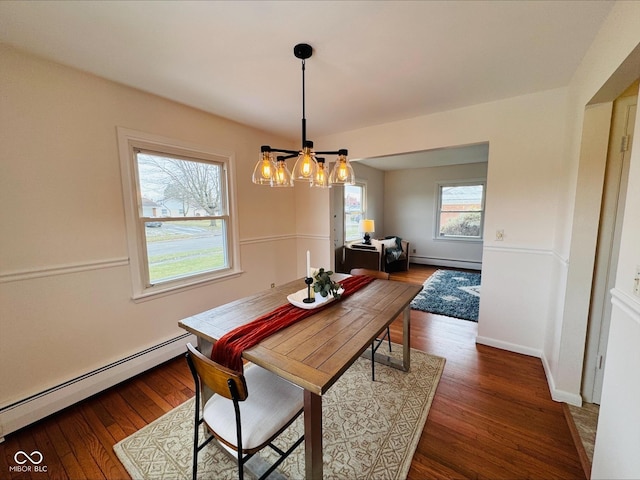 dining room featuring dark wood-type flooring, baseboards, baseboard heating, and an inviting chandelier