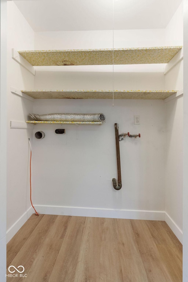 laundry room featuring laundry area, wood finished floors, and baseboards