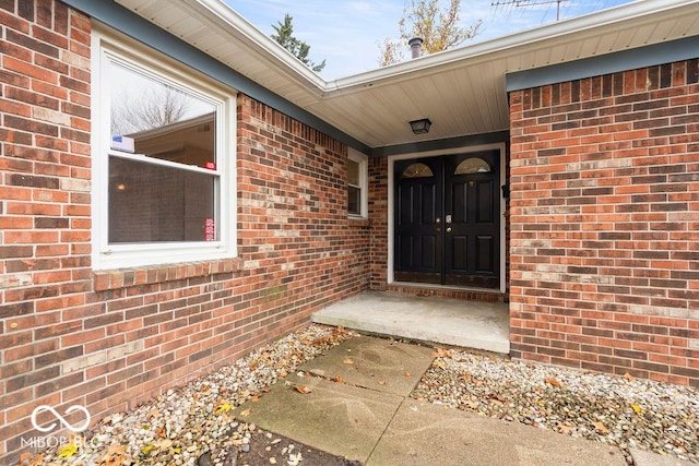 view of exterior entry with brick siding