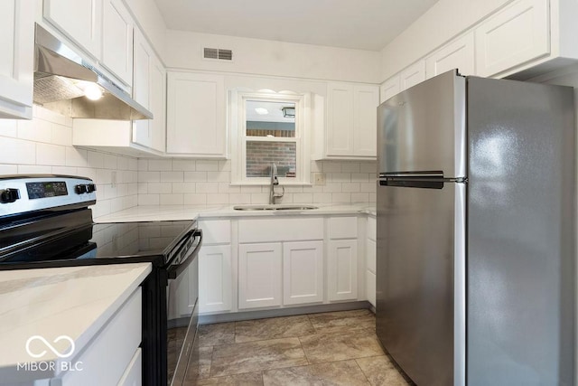 kitchen with electric range, visible vents, freestanding refrigerator, under cabinet range hood, and a sink