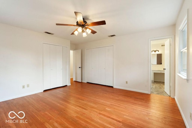 unfurnished bedroom with light wood-style flooring, visible vents, and baseboards