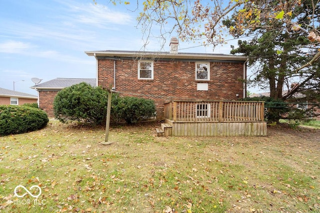 rear view of house with brick siding, a lawn, and a chimney