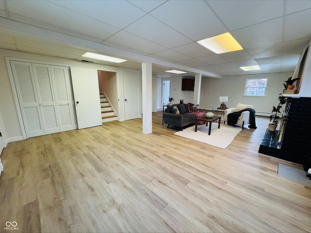 interior space featuring light wood-style flooring, stairs, and a drop ceiling