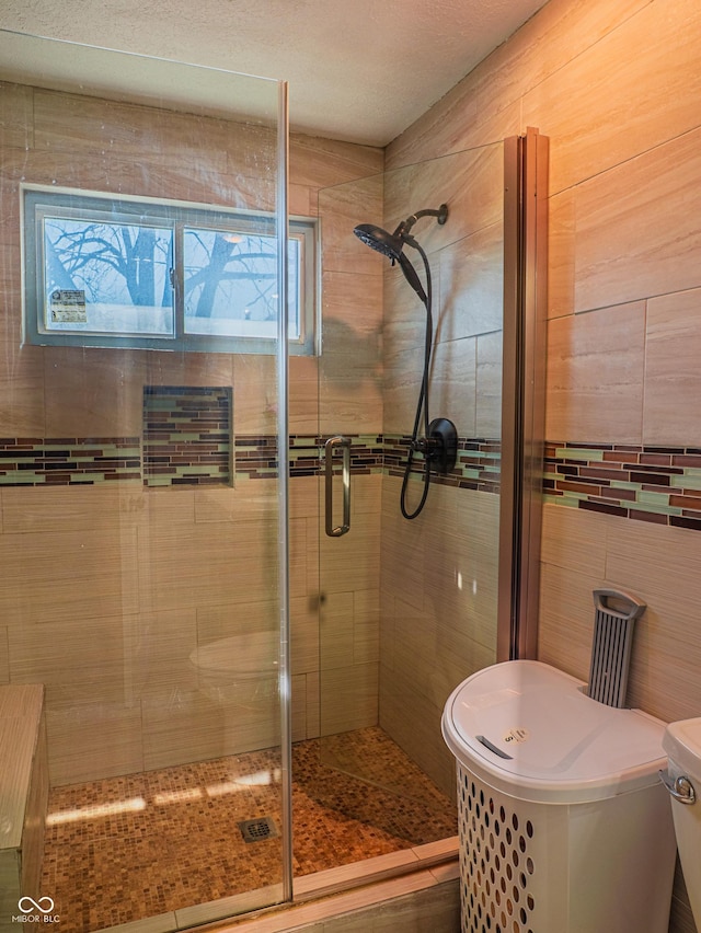 bathroom featuring a shower stall, toilet, and tile walls