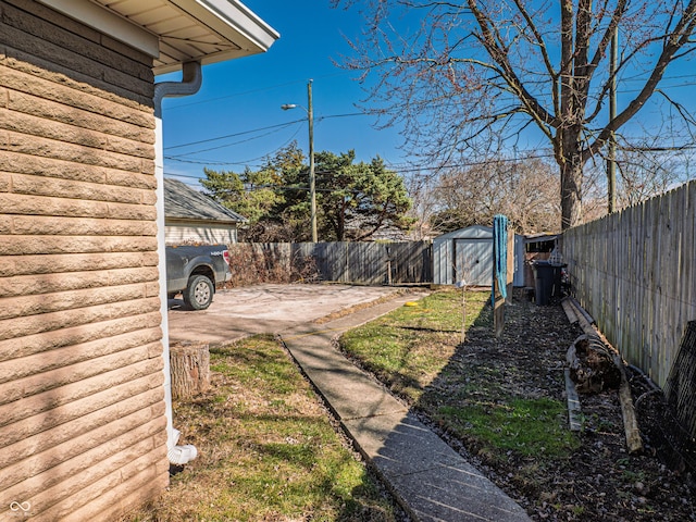 view of yard featuring a storage shed, a patio, an outdoor structure, and a fenced backyard