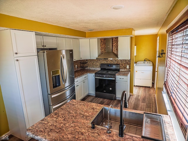 kitchen with stainless steel appliances, dark wood-type flooring, backsplash, wall chimney exhaust hood, and washer / dryer