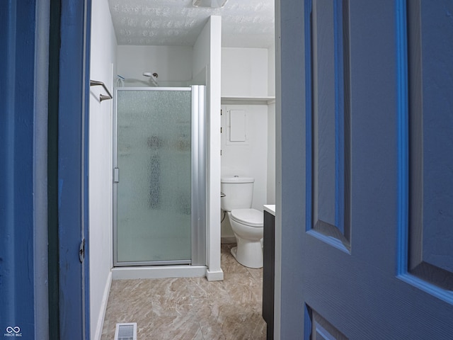 full bathroom featuring a stall shower, visible vents, a textured ceiling, and toilet