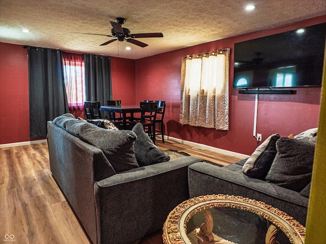 living room with a textured ceiling, recessed lighting, wood finished floors, a ceiling fan, and baseboards