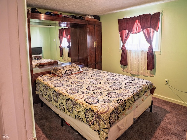 bedroom featuring a textured ceiling, carpet, and baseboards