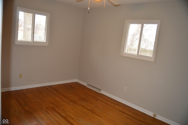 empty room featuring visible vents, ceiling fan, baseboards, and wood finished floors