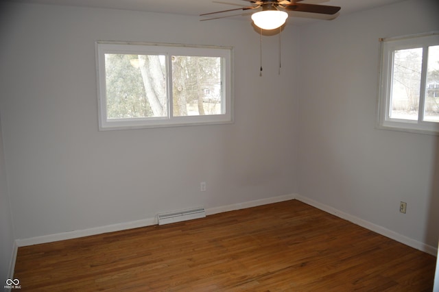 empty room with dark wood-type flooring, a ceiling fan, visible vents, and baseboards