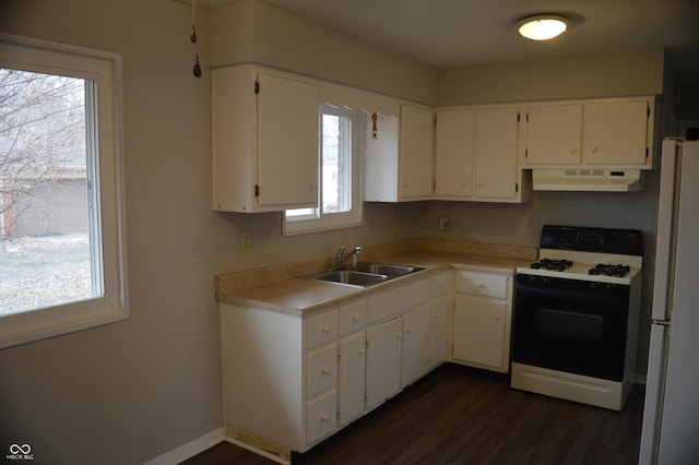 kitchen featuring range with gas cooktop, freestanding refrigerator, light countertops, under cabinet range hood, and white cabinetry