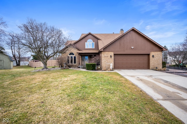 view of front of house with an attached garage, brick siding, fence, and a front lawn