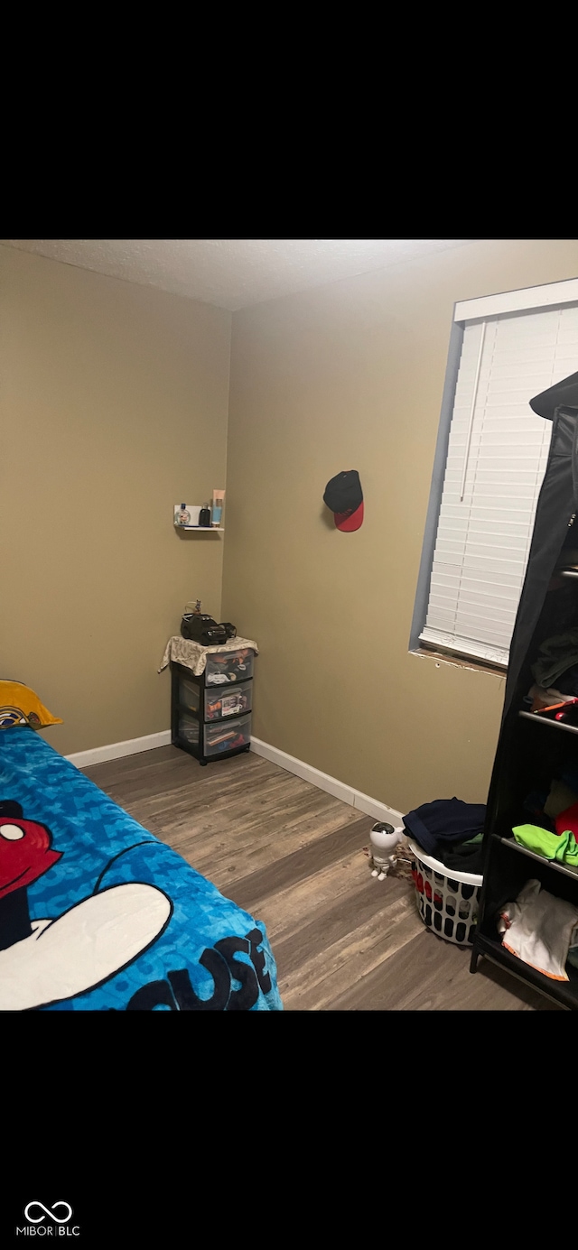 bedroom featuring baseboards and wood finished floors