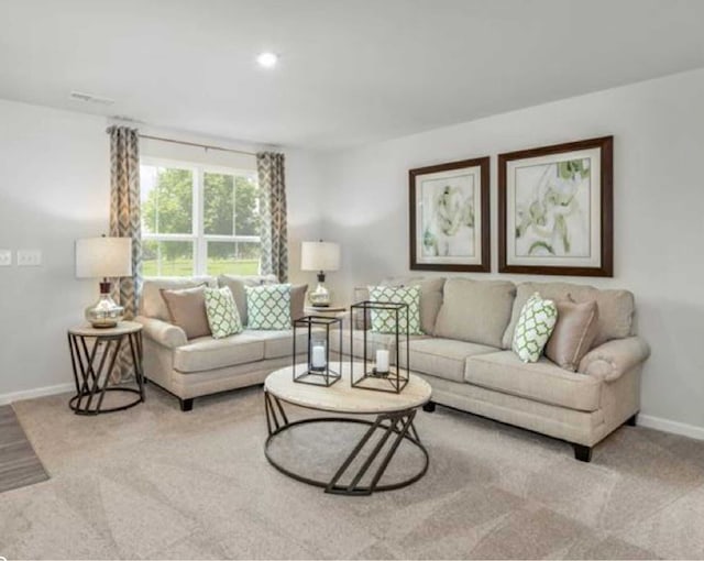 living area featuring baseboards and light colored carpet